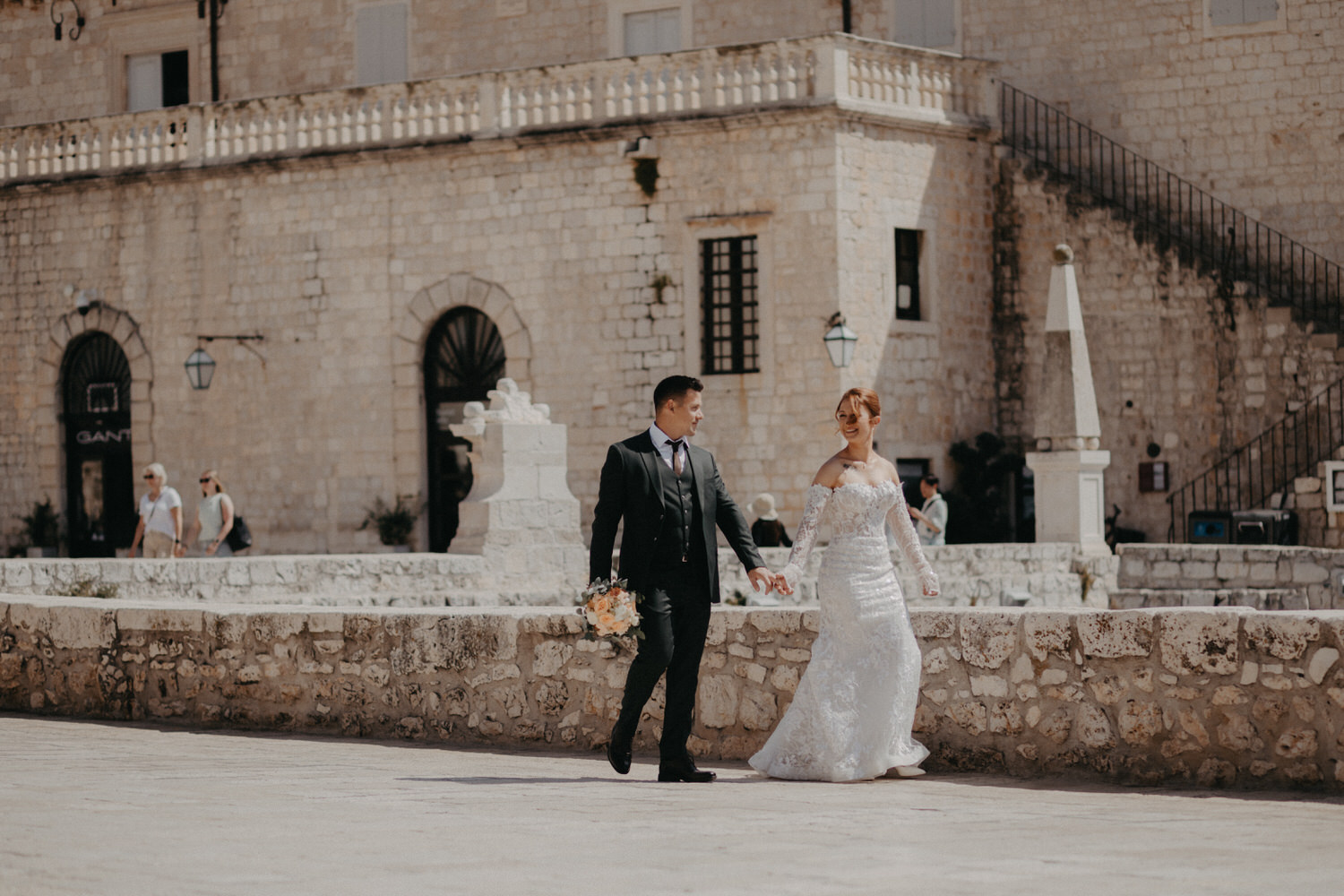 Bride and groom walking through historic Hvar during a destination wedding in Croatia