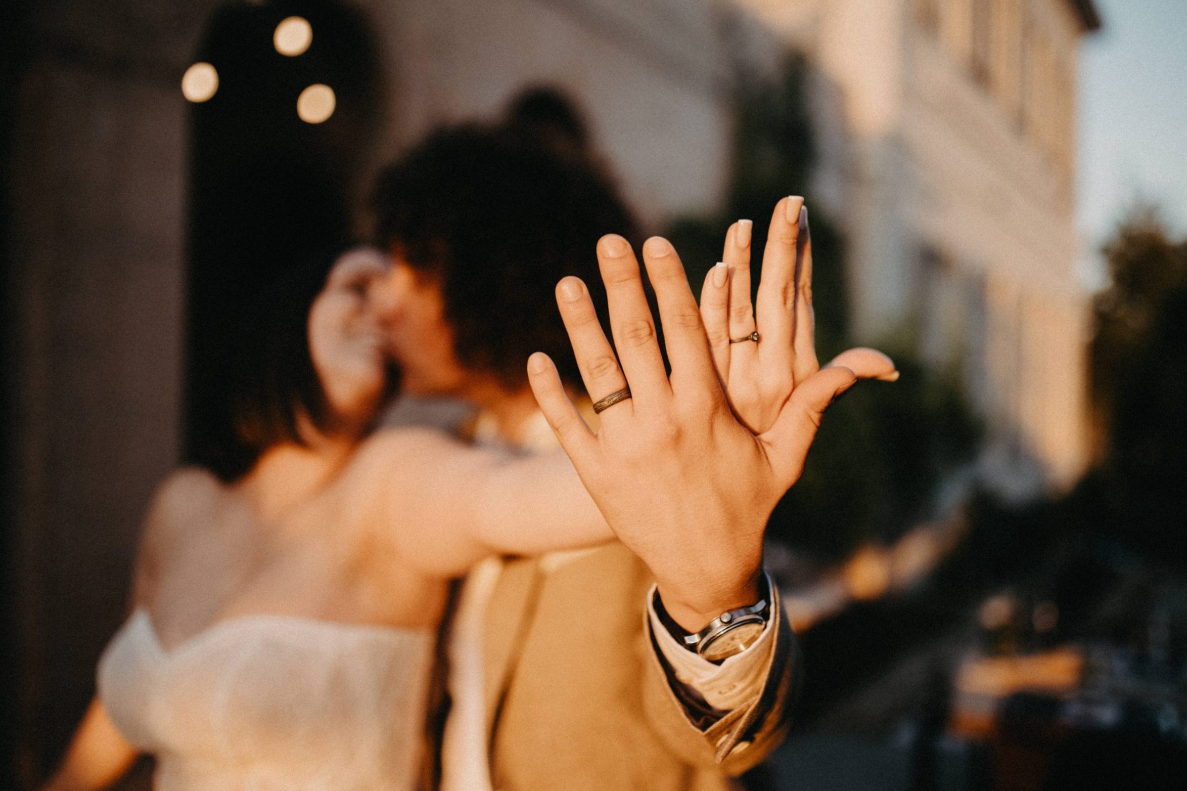 Mladenci pokazuju vjenčane prstene u zlatnom svjetlu zalaska sunca ispred Stare škole Krasica.